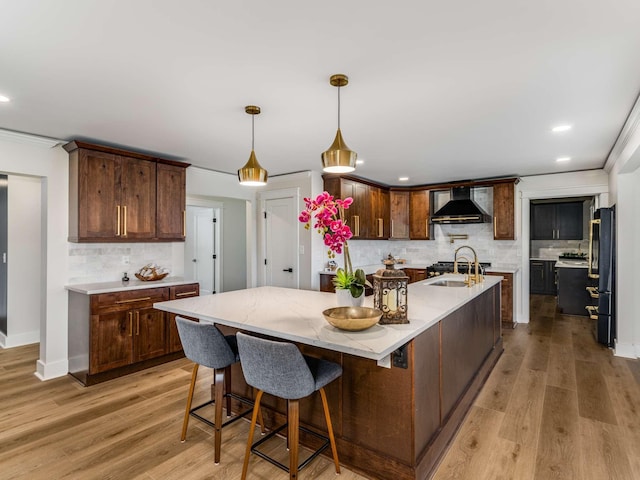 1015 Jump Off Rd, Bon Aqua, TN 37025 - kitchen with wall chimney exhaust hood, tasteful backsplash, a large island, light wood-type flooring, and recessed lighting