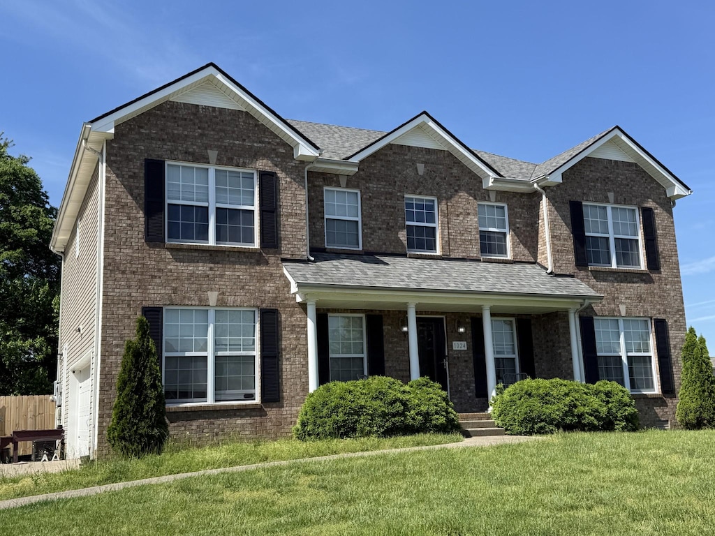 1024 Glenhurst Way, Clarksville, TN 37040 - view of front of house featuring a front yard, covered porch, brick siding, and roof with shingles