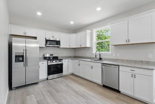 217 Dunnaway St, Shelbyville, TN 37160 - kitchen with appliances with stainless steel finishes, light wood-style flooring, white cabinetry, recessed lighting, and light stone counters