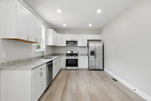 219 Dunnaway St, Shelbyville, TN 37160 - kitchen featuring appliances with stainless steel finishes, light wood-style flooring, white cabinetry, recessed lighting, and light stone countertops