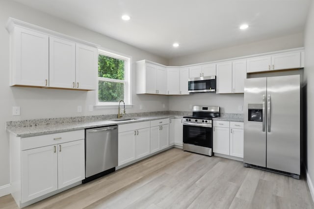 219 Dunnaway St, Shelbyville, TN 37160 - kitchen with appliances with stainless steel finishes, white cabinetry, light wood-style floors, recessed lighting, and light stone counters