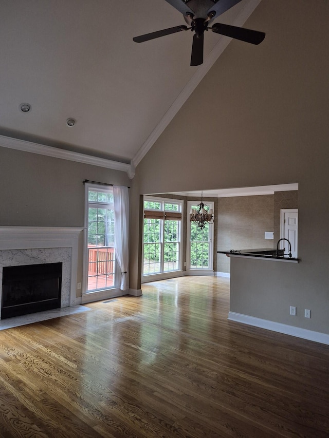 915 Joel Cheek Blvd, Franklin, TN 37064 - unfurnished living room featuring high vaulted ceiling, ornamental molding, a chandelier, a fireplace, and wood finished floors