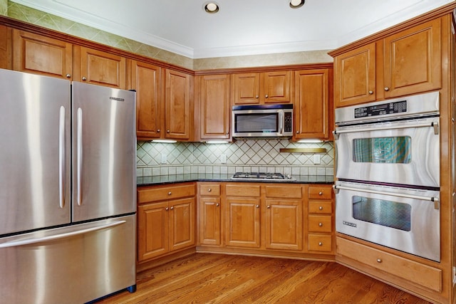 915 Joel Cheek Blvd, Franklin, TN 37064 - kitchen with appliances with stainless steel finishes, brown cabinets, light wood-style floors, decorative backsplash, and recessed lighting