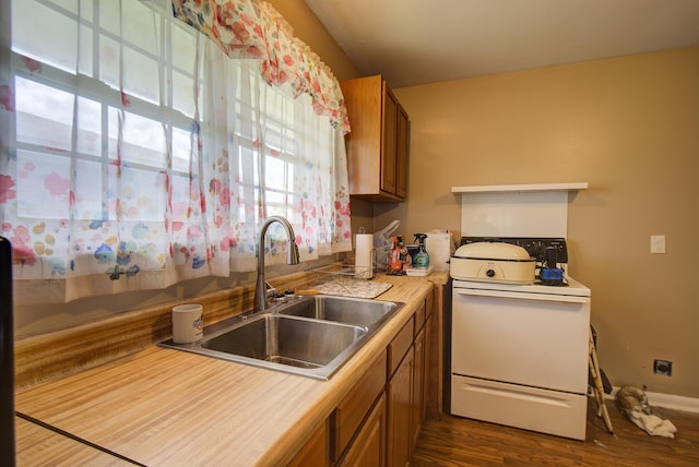 1609 E 26th St, Chattanooga, TN 37407 - kitchen featuring white range oven, brown cabinetry, dark wood-style floors, and light countertops