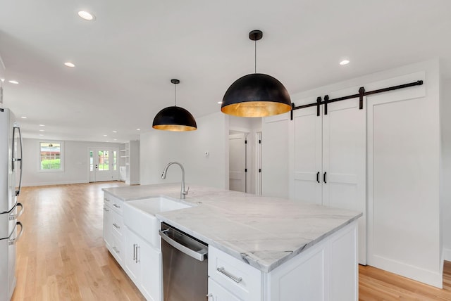 300 Natchez St, Franklin, TN 37064 - kitchen featuring stainless steel appliances, open floor plan, a barn door, white cabinets, and light wood-type flooring