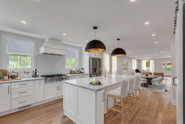 300 Natchez St, Franklin, TN 37064 - kitchen featuring custom range hood, appliances with stainless steel finishes, white cabinets, plenty of natural light, and recessed lighting