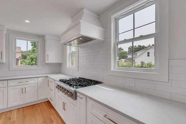 300 Natchez St, Franklin, TN 37064 - kitchen featuring custom range hood, stainless steel gas stovetop, tasteful backsplash, light countertops, and white cabinets