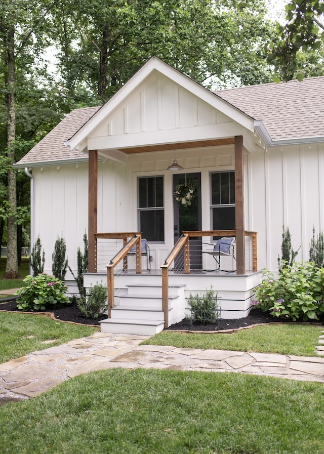4150 Knipfer Rd, Joelton, TN 37080 - view of front facade featuring board and batten siding, a shingled roof, a porch, and a front lawn
