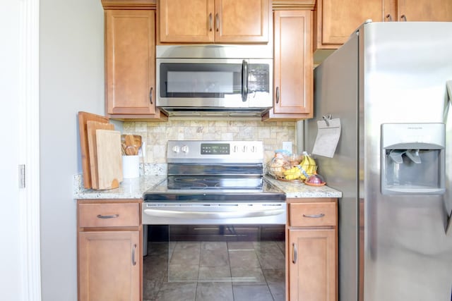 1029 Charles Thomas Dr, Clarksville, TN 37042 - kitchen featuring stainless steel appliances, tasteful backsplash, light stone counters, and tile patterned floors