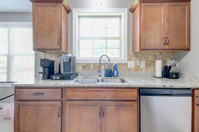 1029 Charles Thomas Dr, Clarksville, TN 37042 - kitchen with stainless steel dishwasher, tasteful backsplash, light stone counters, and brown cabinetry