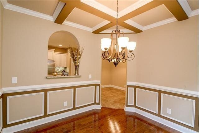 1789 Double R Blvd, Clarksville, TN 37042 - empty room featuring coffered ceiling, beam ceiling, wood finished floors, a chandelier, and arched walkways