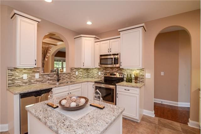 1789 Double R Blvd, Clarksville, TN 37042 - kitchen with stainless steel appliances, arched walkways, tasteful backsplash, white cabinets, and recessed lighting