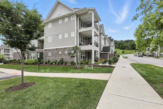 1000 Vintage Green Ln Unit 1201, Franklin, TN 37064 - view of home's exterior with board and batten siding, brick siding, a yard, and a balcony