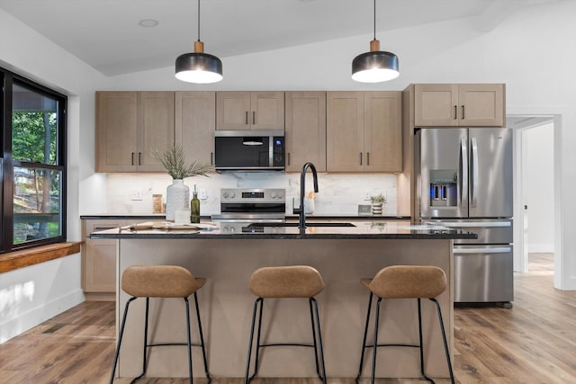 263 Eleanor Dr SW, Cleveland, TN 37311 - kitchen featuring appliances with stainless steel finishes, a kitchen bar, light wood finished floors, decorative backsplash, and vaulted ceiling