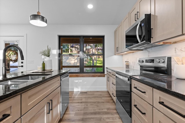 263 Eleanor Dr SW, Cleveland, TN 37311 - kitchen with appliances with stainless steel finishes, dark stone counters, hanging light fixtures, tasteful backsplash, and light wood-type flooring