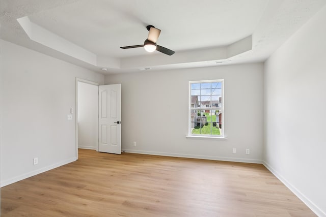 1033 Tom Hailey Blvd, La Vergne, TN 37086 - spare room with light wood-style flooring, a ceiling fan, and a raised ceiling