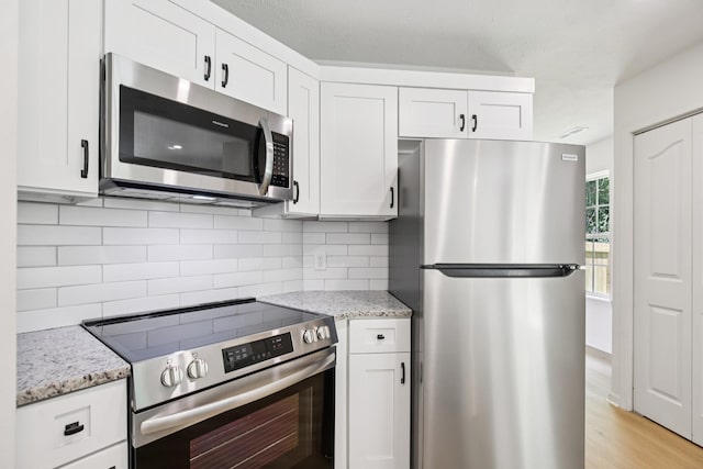 1033 Tom Hailey Blvd, La Vergne, TN 37086 - kitchen featuring stainless steel appliances, tasteful backsplash, white cabinets, and light stone counters