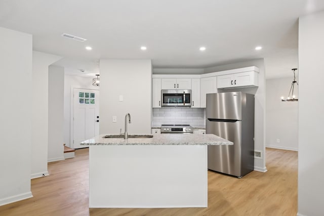 1033 Tom Hailey Blvd, La Vergne, TN 37086 - kitchen featuring stainless steel appliances, light wood-style floors, tasteful backsplash, light stone countertops, and recessed lighting