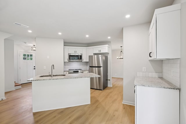 1033 Tom Hailey Blvd, La Vergne, TN 37086 - kitchen with appliances with stainless steel finishes, backsplash, light wood finished floors, white cabinets, and recessed lighting