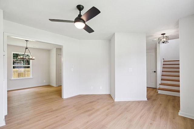 1033 Tom Hailey Blvd, La Vergne, TN 37086 - empty room with a chandelier, light wood finished floors, stairs, and a ceiling fan