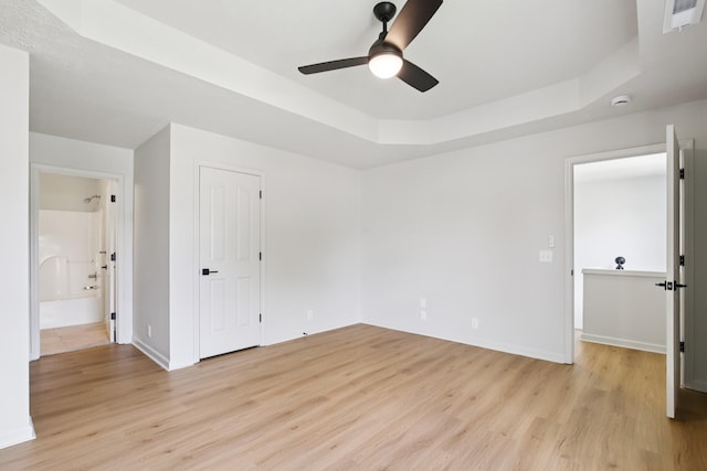 1033 Tom Hailey Blvd, La Vergne, TN 37086 - unfurnished bedroom featuring light wood-style flooring, a raised ceiling, ensuite bathroom, and a ceiling fan