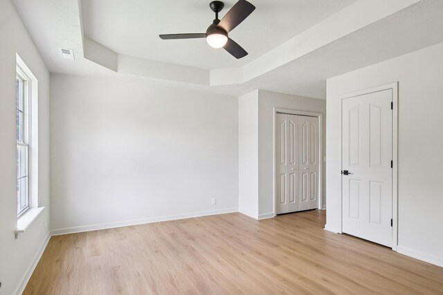 1033 Tom Hailey Blvd, La Vergne, TN 37086 - unfurnished bedroom with light wood finished floors, ceiling fan, a tray ceiling, and a closet