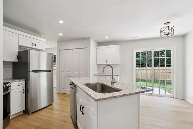 1033 Tom Hailey Blvd, La Vergne, TN 37086 - kitchen featuring stainless steel appliances, backsplash, light wood finished floors, white cabinetry, and recessed lighting