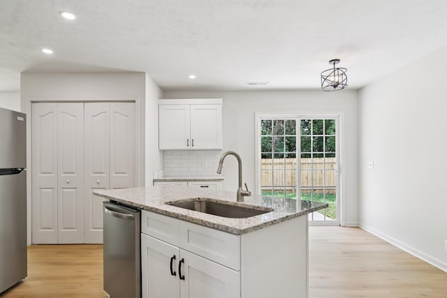 1033 Tom Hailey Blvd, La Vergne, TN 37086 - kitchen with appliances with stainless steel finishes, white cabinetry, light wood finished floors, recessed lighting, and a center island with sink