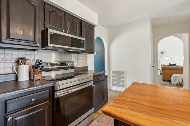 121 La View Rd, Hendersonville, TN 37075 - kitchen featuring stainless steel appliances, arched walkways, dark brown cabinetry, and backsplash