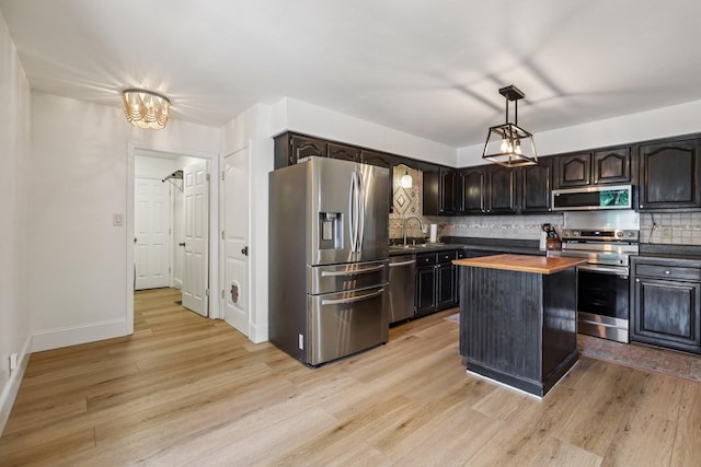 121 La View Rd, Hendersonville, TN 37075 - kitchen featuring appliances with stainless steel finishes, light wood-style floors, tasteful backsplash, and dark brown cabinetry