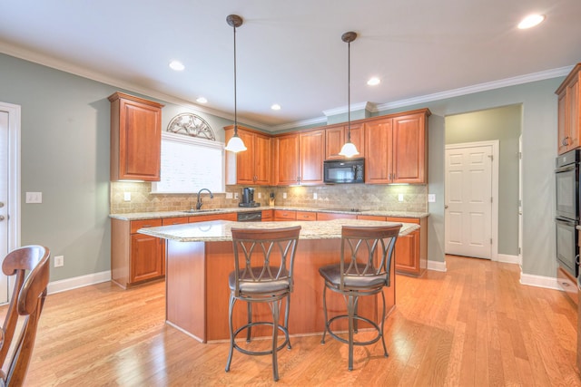 1222 Broadmoor Cir, Franklin, TN 37067 - kitchen featuring black appliances, ornamental molding, a center island, decorative backsplash, and decorative light fixtures