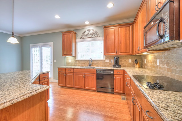 1222 Broadmoor Cir, Franklin, TN 37067 - kitchen featuring black appliances, brown cabinetry, healthy amount of natural light, ornamental molding, and light wood-type flooring