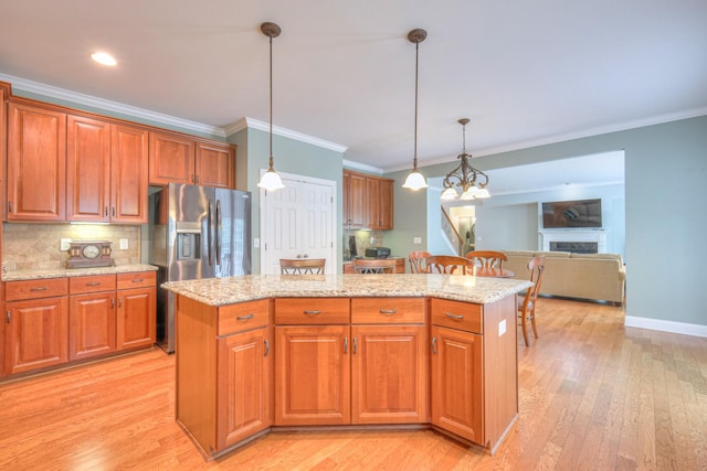 1222 Broadmoor Cir, Franklin, TN 37067 - kitchen with stainless steel fridge with ice dispenser, ornamental molding, a center island, light stone countertops, and decorative light fixtures