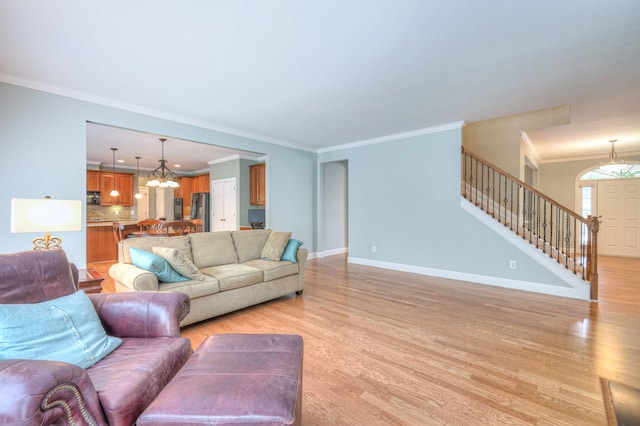 1222 Broadmoor Cir, Franklin, TN 37067 - living room featuring a chandelier, light wood finished floors, stairway, and ornamental molding