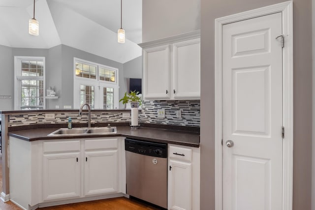1057 Nealcrest Cir, Spring Hill, TN 37174 - kitchen with stainless steel dishwasher, dark countertops, a peninsula, decorative backsplash, and white cabinetry
