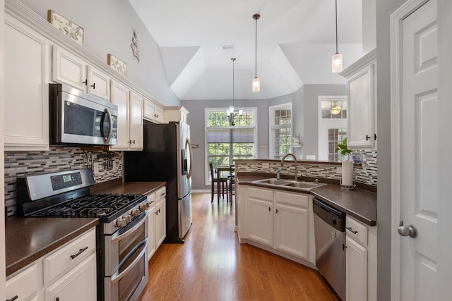 1057 Nealcrest Cir, Spring Hill, TN 37174 - kitchen featuring appliances with stainless steel finishes, dark countertops, a chandelier, a peninsula, and vaulted ceiling
