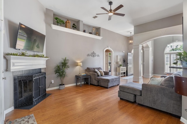 1057 Nealcrest Cir, Spring Hill, TN 37174 - living area featuring arched walkways, ornate columns, ceiling fan, a fireplace, and wood finished floors