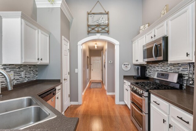 1057 Nealcrest Cir, Spring Hill, TN 37174 - kitchen featuring appliances with stainless steel finishes, arched walkways, dark countertops, and a high ceiling