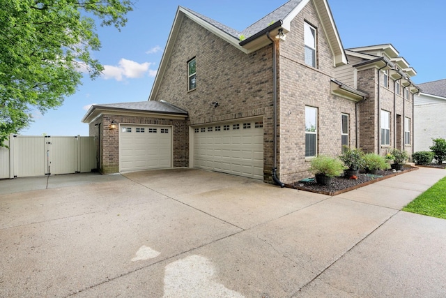 2957 Stewart Campbell Pt, Spring Hill, TN 37174 - view of property exterior featuring driveway, a gate, brick siding, and a garage