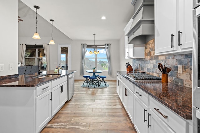 2957 Stewart Campbell Pt, Spring Hill, TN 37174 - kitchen with appliances with stainless steel finishes, light wood finished floors, decorative backsplash, a chandelier, and custom range hood