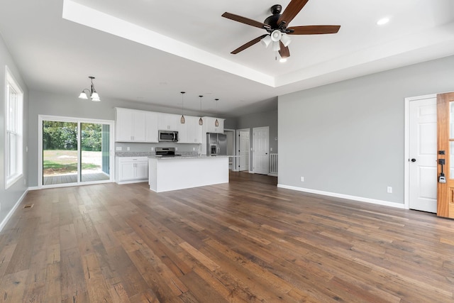 1554 Duncans Chapel Rd, Cookeville, TN 38506 - unfurnished living room with a chandelier, ceiling fan, dark wood-style flooring, recessed lighting, and a raised ceiling