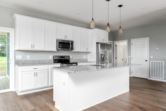 1554 Duncans Chapel Rd, Cookeville, TN 38506 - kitchen featuring appliances with stainless steel finishes, dark wood-style flooring, a center island with sink, white cabinetry, and decorative light fixtures