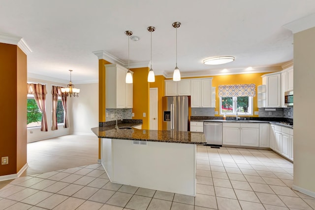 822 Old Jefferson Pike, Smyrna, TN 37167 - kitchen featuring stainless steel appliances, a peninsula, healthy amount of natural light, a chandelier, and crown molding