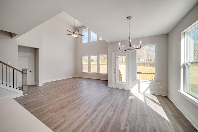 7274 Fairlawn Dr, Fairview, TN 37062 - unfurnished living room with wood finished floors, a chandelier, stairs, ceiling fan, and high vaulted ceiling