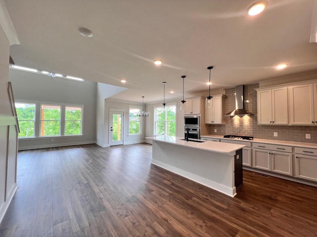 7274 Fairlawn Dr, Fairview, TN 37062 - kitchen featuring wall chimney exhaust hood, appliances with stainless steel finishes, light countertops, a kitchen island with sink, and dark wood-style floors