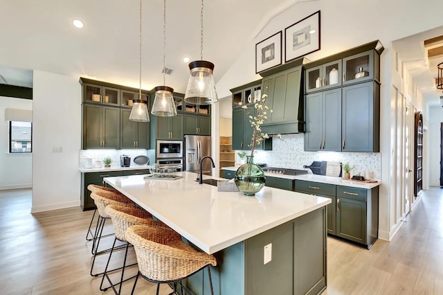 7235 Fairlawn Dr, Fairview, TN 37062 - kitchen with appliances with stainless steel finishes, light wood-style flooring, backsplash, light countertops, and a large island