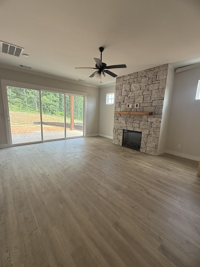 7253 Fairlawn Dr, Fairview, TN 37062 - unfurnished living room featuring wood finished floors, ceiling fan, a stone fireplace, and crown molding
