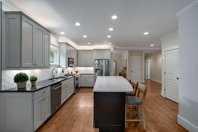 162 Woodmont Blvd, Nashville, TN 37205 - kitchen with appliances with stainless steel finishes, gray cabinetry, ornamental molding, a kitchen bar, and a kitchen island