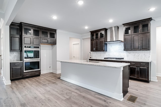 7266 Fairlawn Dr, Fairview, TN 37062 - kitchen featuring wall chimney range hood, stainless steel appliances, crown molding, tasteful backsplash, and light wood-style flooring
