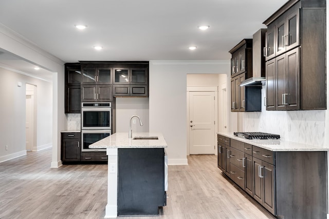 7266 Fairlawn Dr, Fairview, TN 37062 - kitchen featuring appliances with stainless steel finishes, wall chimney exhaust hood, crown molding, tasteful backsplash, and light wood-style floors